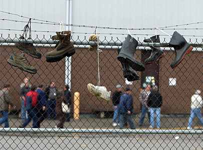 Work boots hang from the fence as the last Canadian GM truck came off of the line at the General Motors truck assembly plant in Oshawa May 14, 2009. The trucks will now be made in Indiana, Michigan and Mexico.