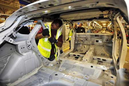 Ford team leader Lenard Mosley fastens an air bag inside a Ford Focus on Tuesday at the Michigan Assembly Plant in Wayne. (John T. Greilick / The Detroit News)