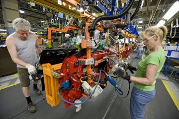 Norm Henderson, left, and Dee Harrison put glass panes into the doors of a Chevrolet Camaro on the assembly line at General Motors of Canada's Oshawa plant on Friday, May 22, 2009