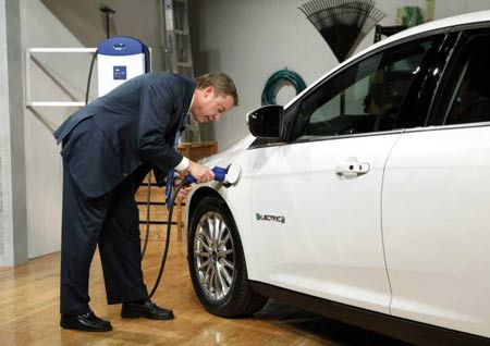 Executive Chairman Bill Ford charges the Focus Electric at its reveal in New York on Friday. It has a range of 100 miles. (Ford)