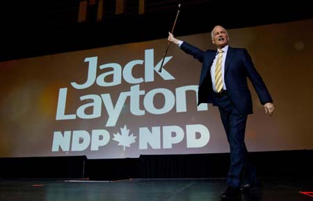 NDP Leader Jack Layton raises his cane as he takes to the stage to deliver his keynote speech at the party's 50th anniversary convention in Vancouver, B.C., on Sunday June 19, 2011.