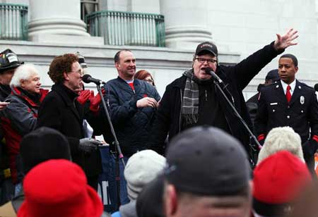 Filmmaker Michael Moore speaks to a crowd during a large march and rally at the Wisconsin State Capitol on March 5, 2011 in Madison, Wisconsin.