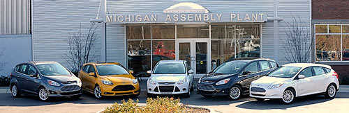 Automotive journalists are greeted by five, 2013 vehicles at the Michigan Assembly Plant in Wayne, including, from left, C-MAX Hybrid, gas-powered Focus 5-door hatchback ST, Focus 4-door sedan SE, C-MAX Energi SEL and the Focus Electric during a tour, Thursday, November 8, 2012. (Todd McInturf / The Detroit News)