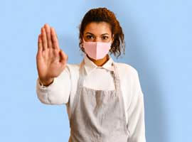 A female hospitality worker holds up her hand to signal 'stop'