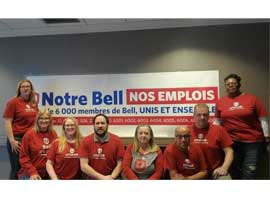 Bell clerical bargaining committee poses in front of a campaign banner.