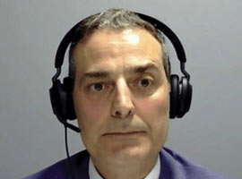 A man wearing a blue suit with headphones.